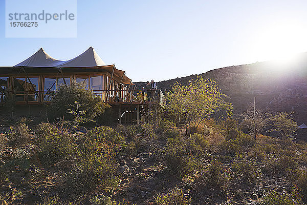 Älteres Paar entspannt sich auf dem sonnigen Balkon eines Safari-Lodge-Hotels