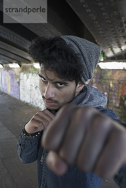 Porträt harter junger Mann beim Stanzen in einem städtischen Tunnel