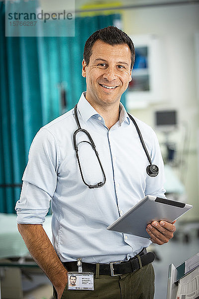 Porträt selbstbewusster männlicher Arzt mit digitalem Tablet im Krankenhaus