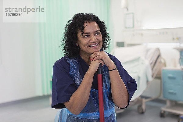 Lächelnde Krankenpflegerin bei der Reinigung einer Krankenstation