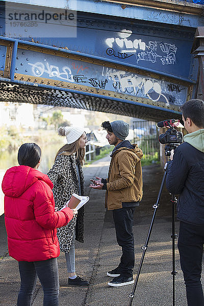 College-Filmstudenten filmen unter einer städtischen Brücke
