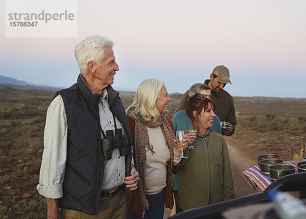 Glückliches Seniorenpaar auf Safari trinkt Champagner
