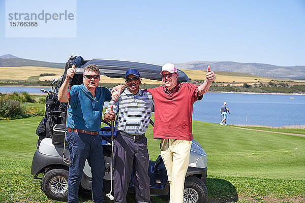 Porträt glücklicher reifer männlicher Golfspieler am Golfwagen auf einem sonnigen Platz