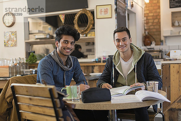 Porträt zuversichtlich  junge männliche Studenten studieren im Café Tisch