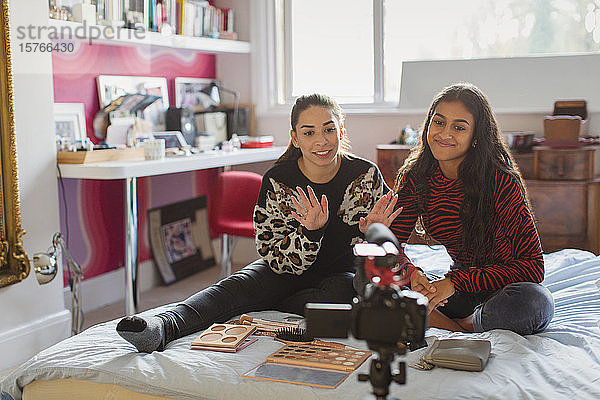 Teenager-Freundinnen Vlogging über Make-up auf dem Bett im Schlafzimmer