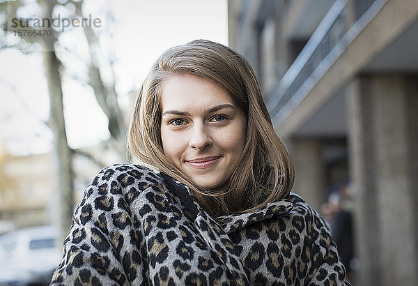 Porträt einer selbstbewussten jungen Frau in einem Mantel mit Leopardenmuster