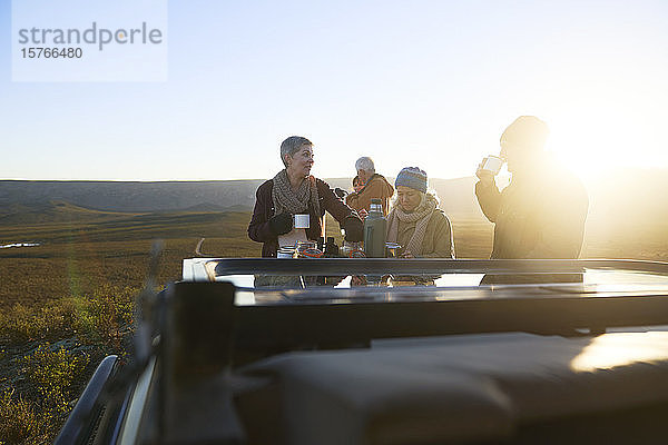Safari-Reisegruppe trinkt Tee bei Sonnenaufgang Südafrika