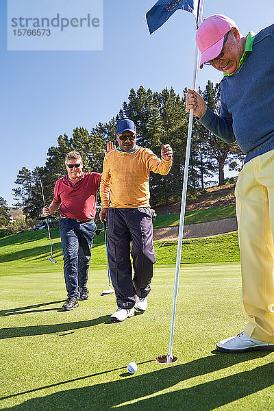 Männliche Golfer am Putting-Green-Loch