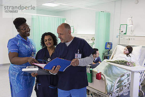 Ärzte und Krankenschwester mit Krankenblatt bei der Visite  Beratung in der Krankenstation