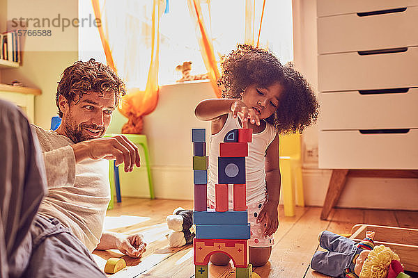 Vater und Tochter spielen mit Holzklötzen