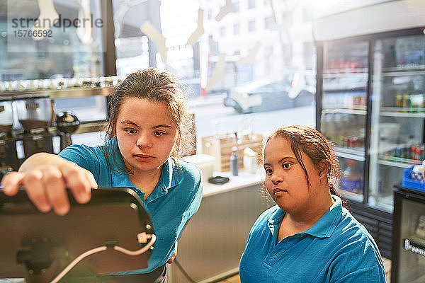 Junge Frauen mit Down-Syndrom arbeiten in einem Cafe