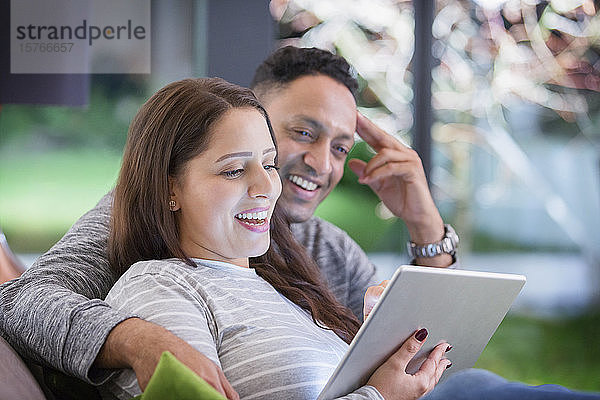 Glückliches Paar  das sich entspannt und ein digitales Tablet benutzt
