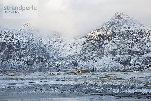 Schneebedeckte Berge und abgelegene Hütten Flakstad Lofoten Norwegen