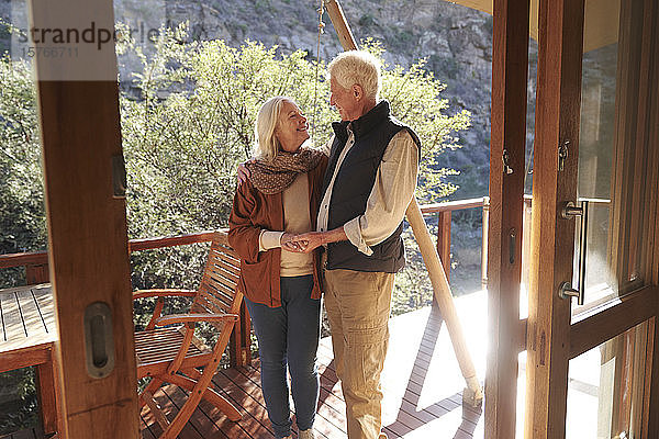 Glückliches  zärtliches älteres Paar auf dem sonnigen Balkon einer Safari-Lodge