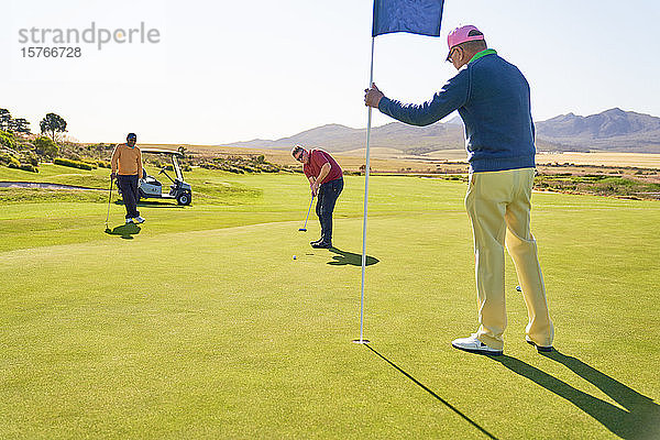 Männer auf sonnigem Golf-Putting-Green