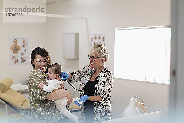 Eine Kinderärztin untersucht ein kleines Mädchen im Untersuchungsraum