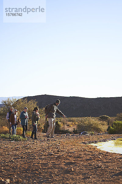 Safari-Reiseleiter führt Gruppe im sonnigen Wildreservat in Südafrika