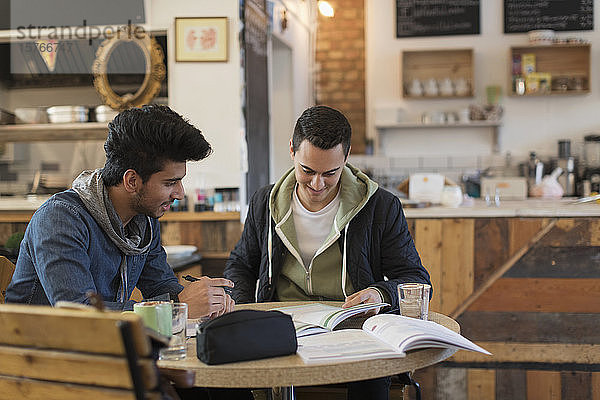 Junge männliche Studenten  die in einem Café lernen