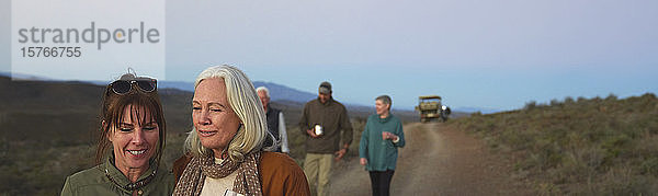 Glückliche Frauen  die auf Safari sind und auf einer unbefestigten Straße spazieren gehen