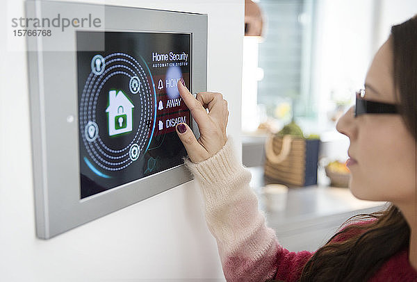 Frau stellt Touchscreen-Hausalarmanlage ein