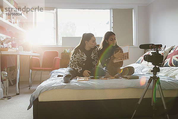 Teenager Mädchen Vlogging über Make-up auf dem Bett in sonnigen Schlafzimmer