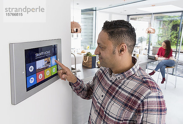 Mann stellt Touchscreen-Smart-Home-Alarm ein