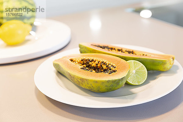 Frisch geschnittene Papaya mit Limette auf dem Teller