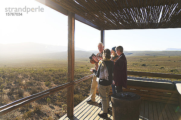 Ältere Freunde auf dem sonnigen Balkon einer Safari-Lodge in Südafrika
