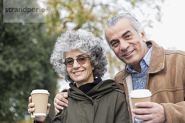 Porträt eines lächelnden  selbstbewussten älteren Paares beim Kaffeetrinken
