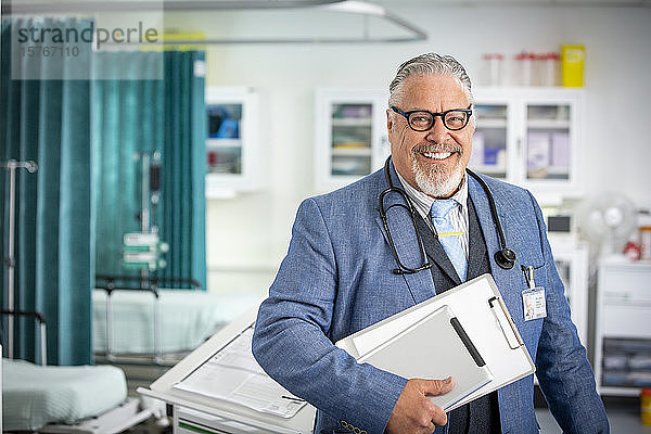 Porträt selbstbewusster männlicher Oberarzt bei der Visite im Krankenhaus