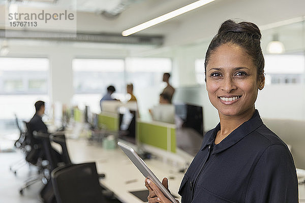 Porträt selbstbewusste lächelnde Geschäftsfrau mit digitalem Tablet im Büro