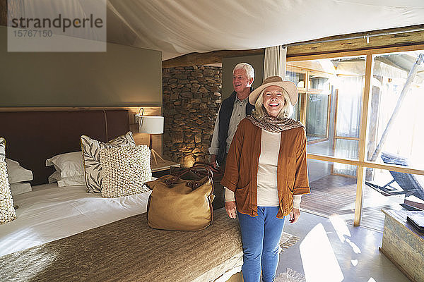 Porträt eines glücklichen älteren Paares bei der Ankunft im Hotelzimmer einer Safari-Lodge