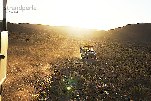 Safari-Geländewagen auf sonniger Schotterpiste in Südafrika