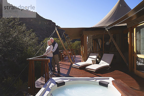 Zärtliches älteres Paar auf dem sonnigen Balkon einer Luxus-Safari-Lodge