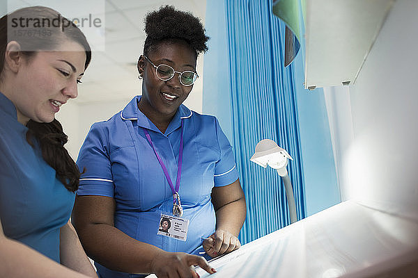 Weibliche Krankenschwestern besprechen den Papierkram im Krankenhauszimmer