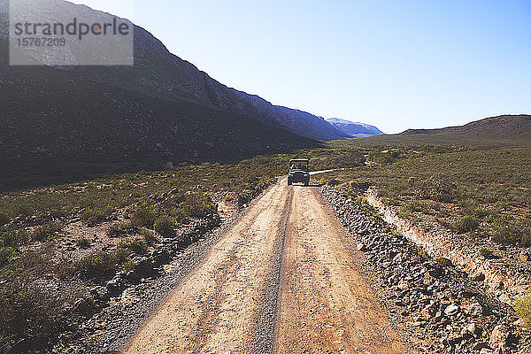 Safari im Geländewagen auf sonniger  abgelegener Schotterpiste in Südafrika
