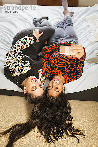 Blick von oben Teenager-Mädchen Freunde nehmen Selfie auf dem Bett