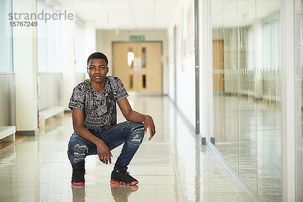 Porträt selbstbewusster High-School-Junge im Korridor