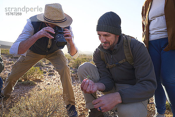 Safari-Führer erklärt einem Touristen mit Kamera die Pflanzen