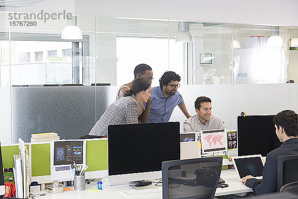 Geschäftsleute treffen sich am Computer in einem Großraumbüro