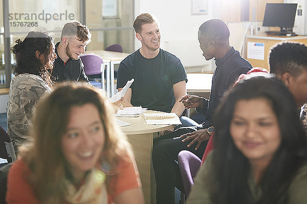 College-Studenten beim Lernen und Reden im sonnigen Klassenzimmer