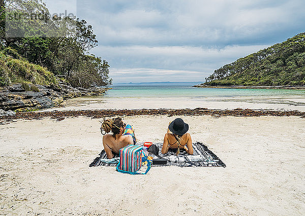 Paar beim Sonnenbaden an einem abgelegenen tropischen Strand in der Jervis Bay  Australien