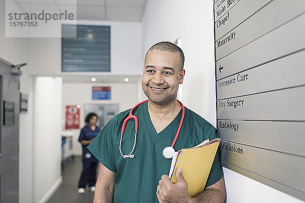 Porträt eines lächelnden  selbstbewussten männlichen Chirurgen im Krankenhausflur