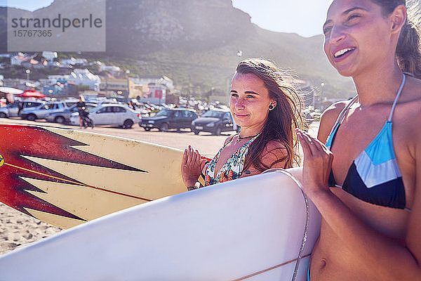 Junge Frauen mit Surfbrettern am sonnigen Sommerstrand