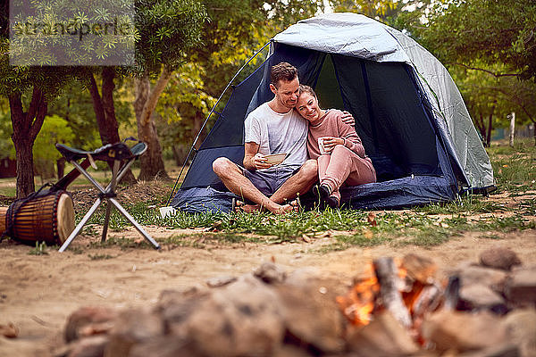 Glückliches  zärtliches Paar entspannt sich im Zelt auf dem Campingplatz