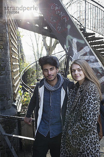 Portrait selbstbewusstes junges Paar neben städtischer Treppe