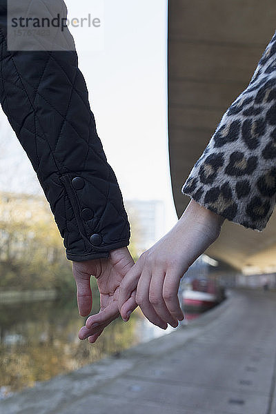 Nahaufnahme zärtliches junges Paar  das sich am Kanal an den Händen hält