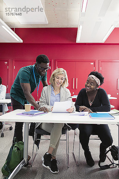 Community College-Dozent hilft Studenten am Schreibtisch im Klassenzimmer