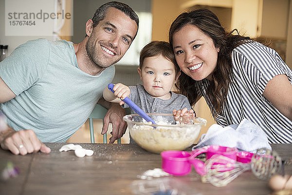 Porträt einer glücklichen jungen Familie beim Backen