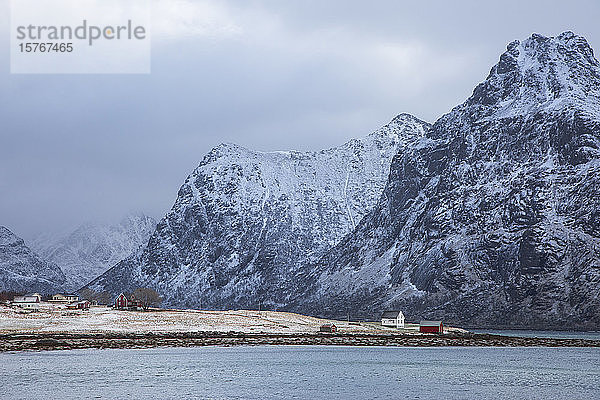 Schneebedeckte Berge über dem Dorf Flakstadpollen Lofoten Norwegen